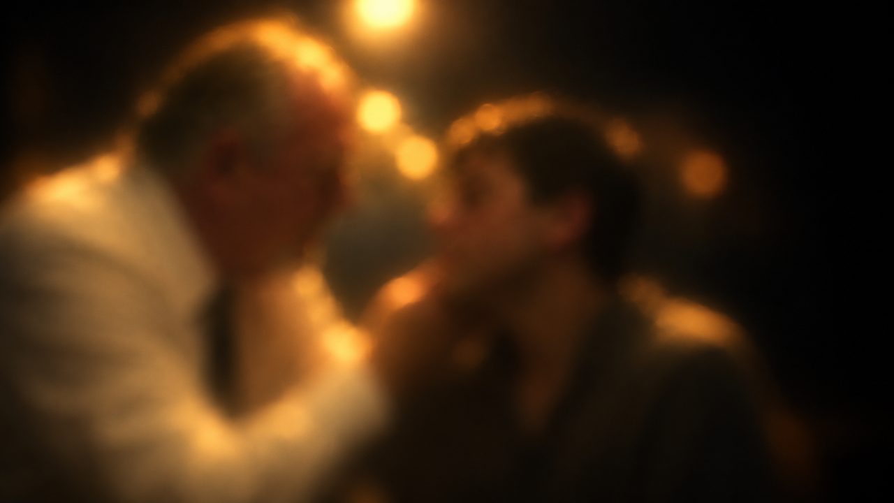 A soft, half-remembered impression of an old man checking a boy's eye in a boxing gym